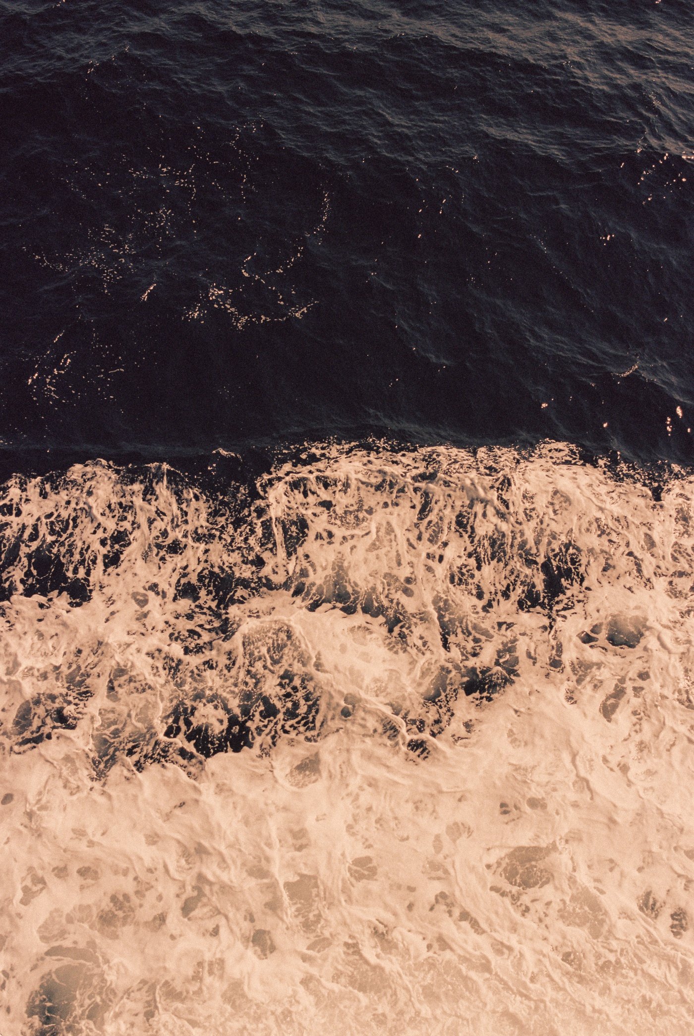 Sea meeting white foam, seen from above