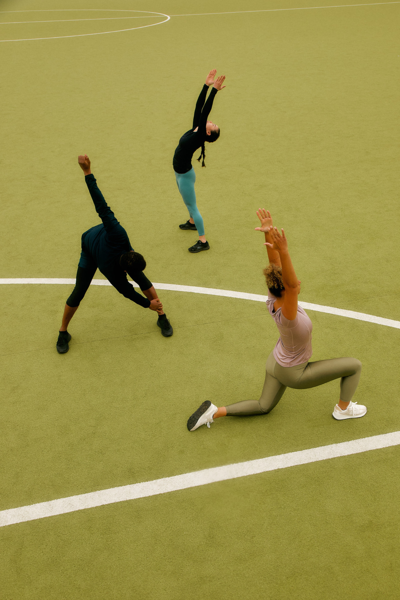 Athletes warming up on a green court